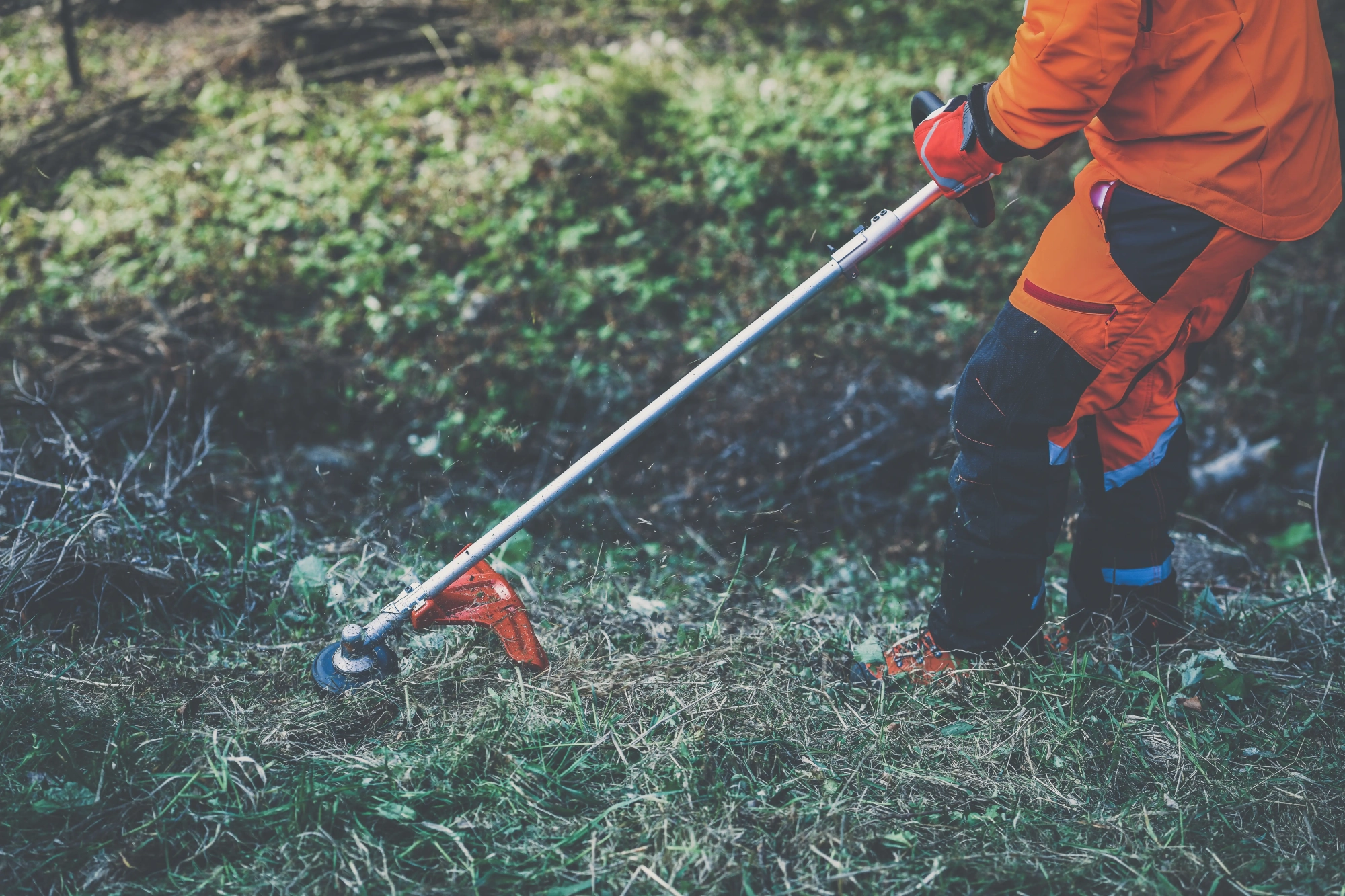 man-holding-brushcutter-cut-grass-brush-lumberjack-work-gardener-working-outdoor-forest