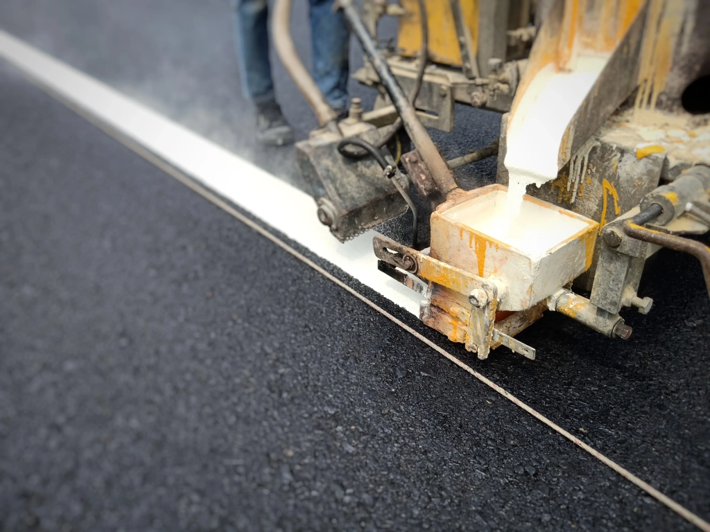 section-basse-de-l-homme-faisant-le-marquage-sur-la-route-avec-une-machine
